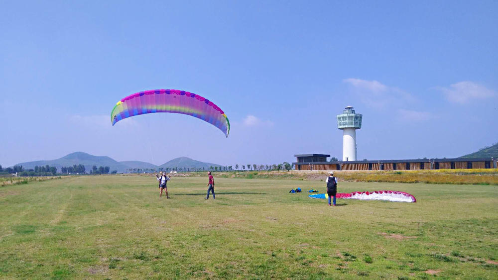 一名游客在许家崖飞行营地体验滑翔伞项目